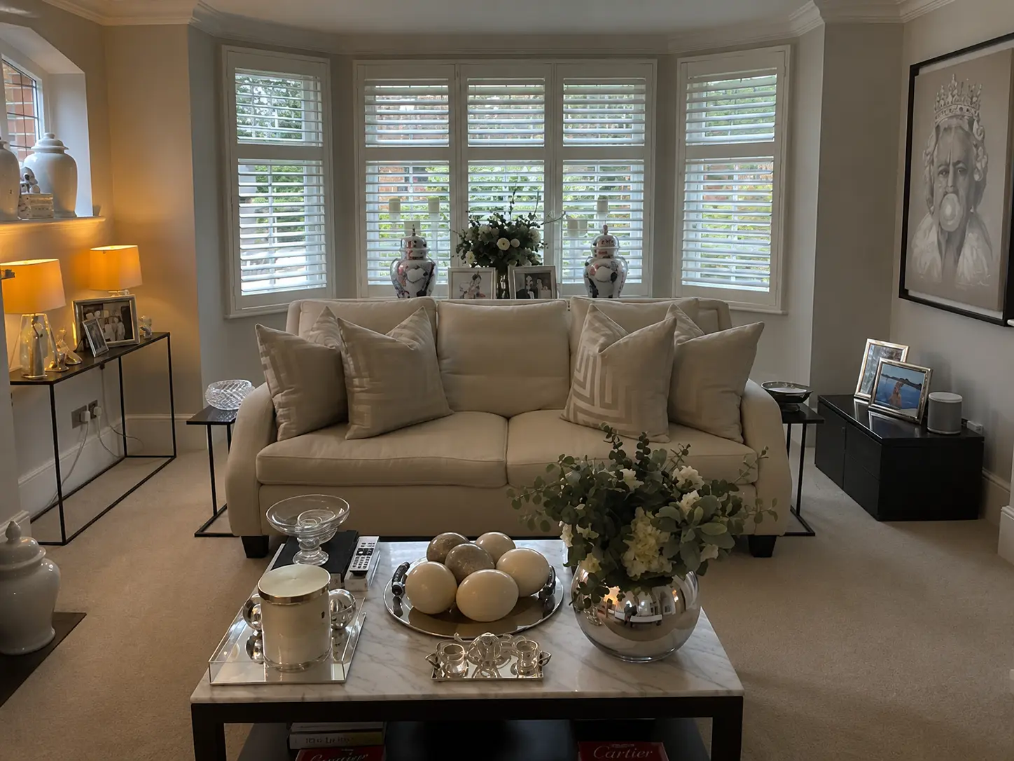 Full-height plantation shutters across a living room bay window