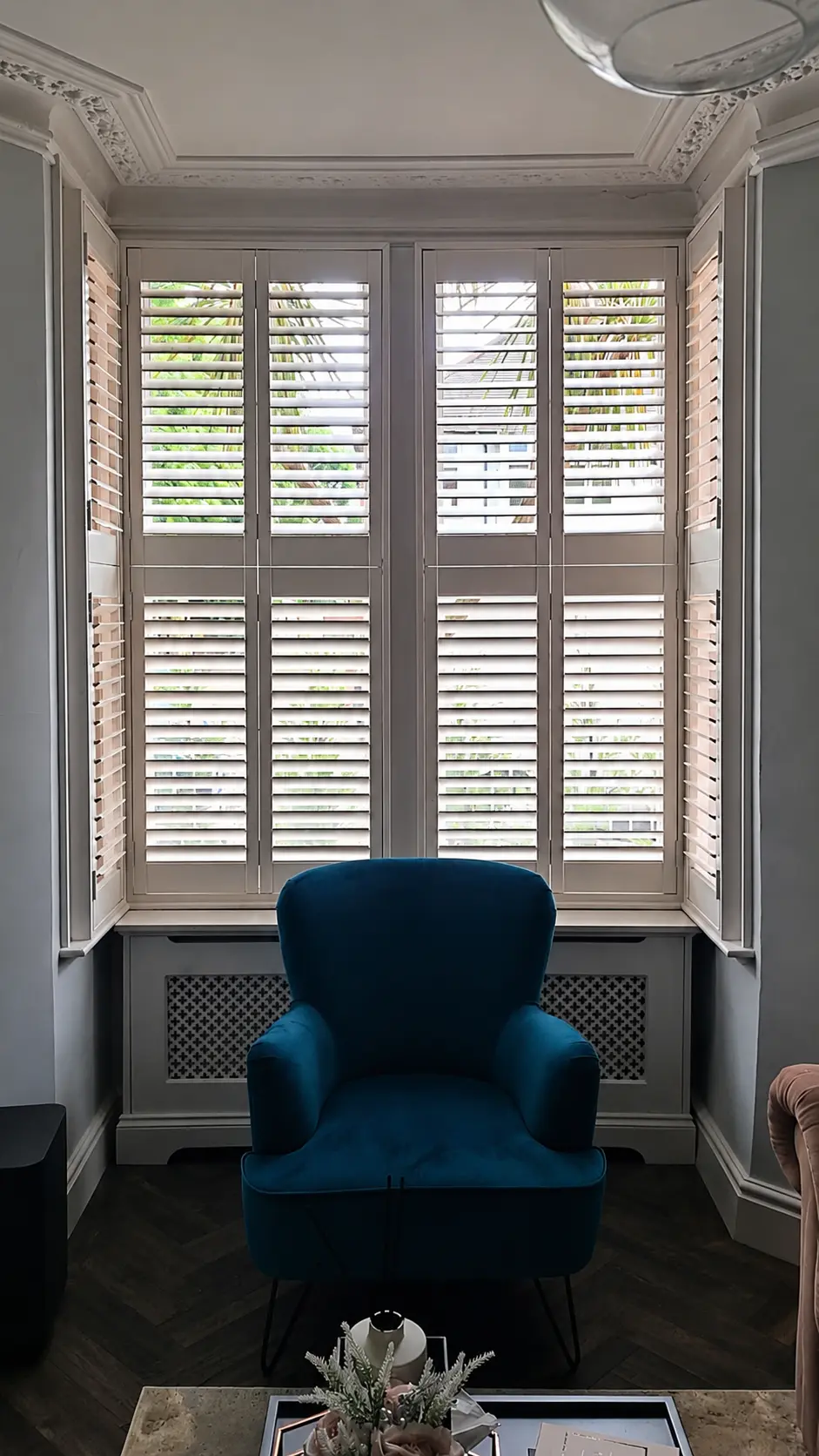 Full-height plantation shutters around a period bay window