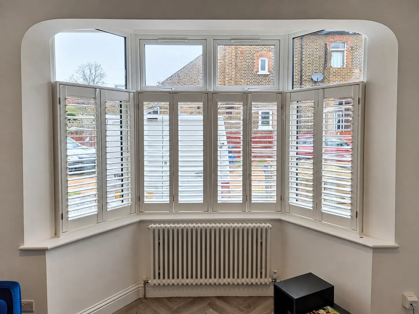 Full-height plantation shutters across a wide bay window